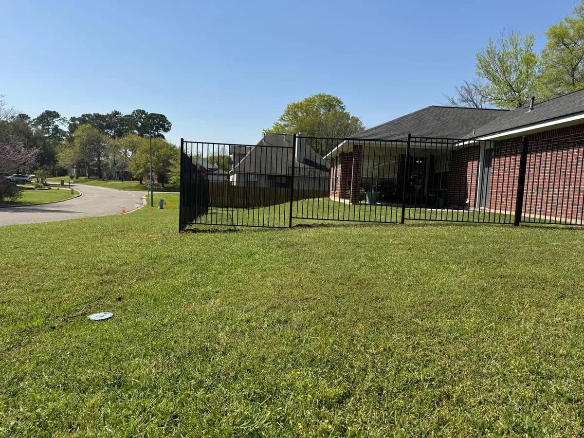 Otra sección de la barda de hierro perimetral (file_45). Sigue la curva del terreno para mantener a mascotas/niños dentro de la propiedad de ladrillo.