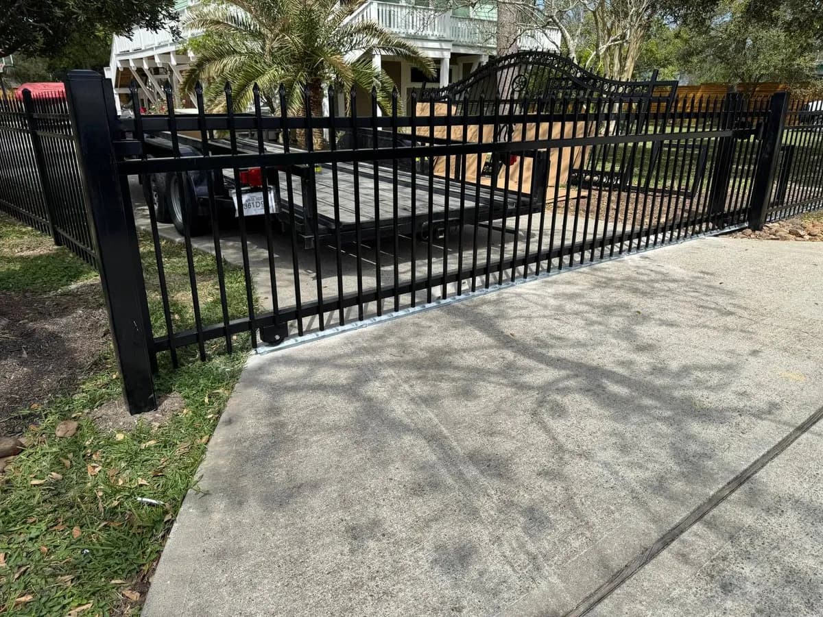 Portón deslizante asimétrico cargado en un remolque tipo flatbed. Diseño de arco con puntas (pikes) arriba y diseño base estándar. Listo para instalación.