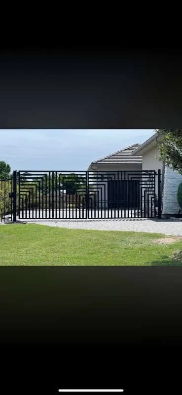 Otra perspectiva (tomada de frente) del portón geométrico laberíntico moderno (file_60). Muestra todo el portón cerrado frente a la propiedad.