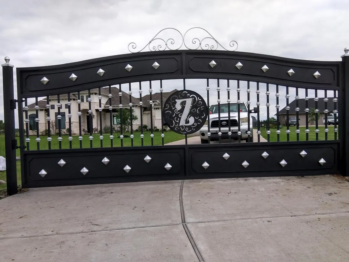 Portón masivo con monograma central 'Z', detalles en plata/cromo y ornamentación superior.