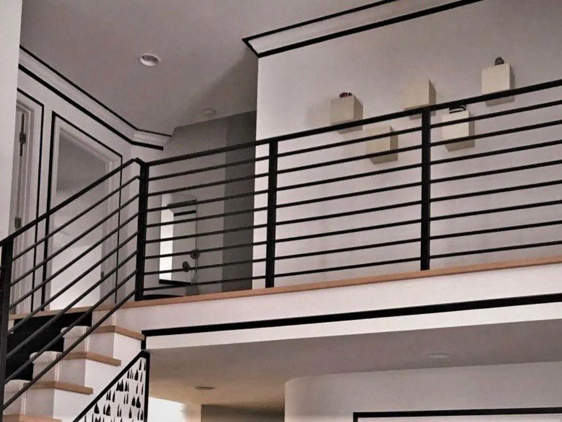 Barandal interior para loft con diseño de perfiles rectangulares negros.